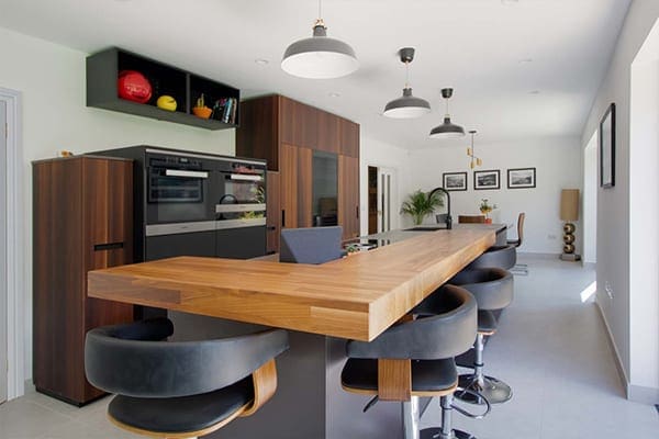 Walnut Next125 kitchen with a large matt black island and seating, designed and installed by Artisan in Cardiff