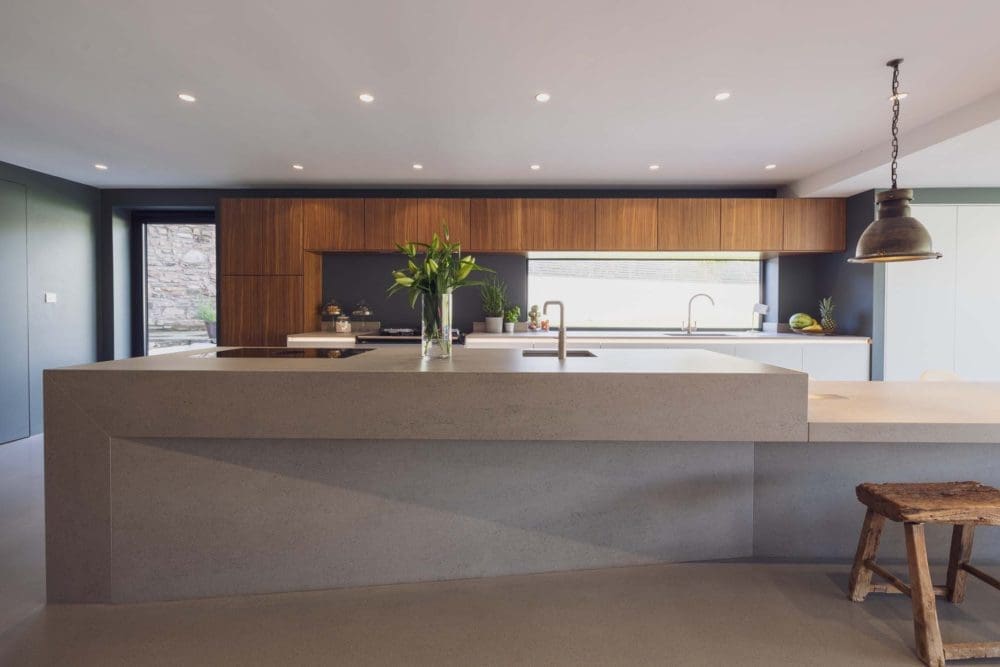 Next 125 walnut kitchen designed by Artisan, featuring a large Dekton island, exemplifying luxury German kitchens in Cardiff