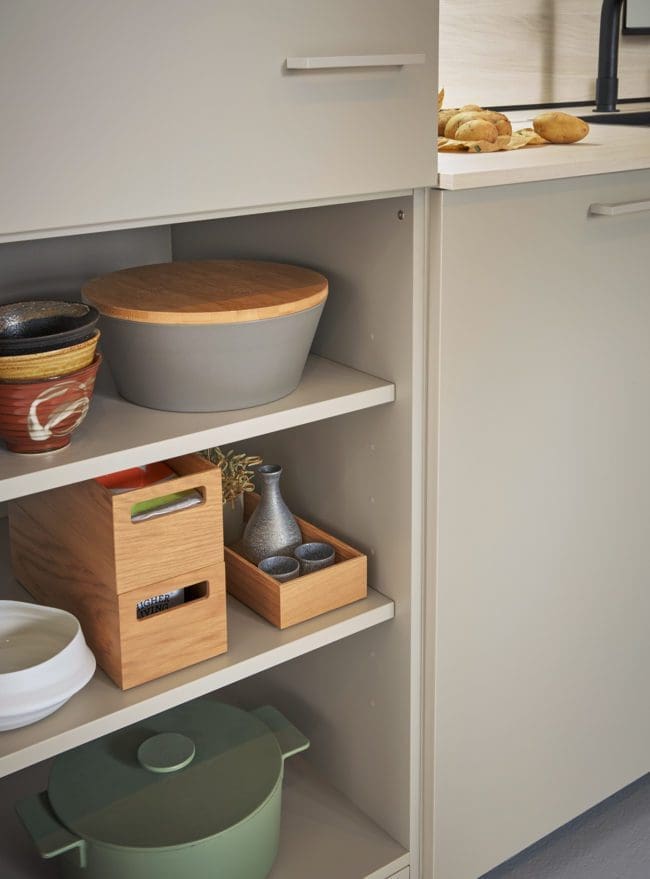 Photograph of an open shelf unit in a Matera kitchen, artfully displaying a range of cooking apparatus, blending functionality with modern kitchen aesthetics.