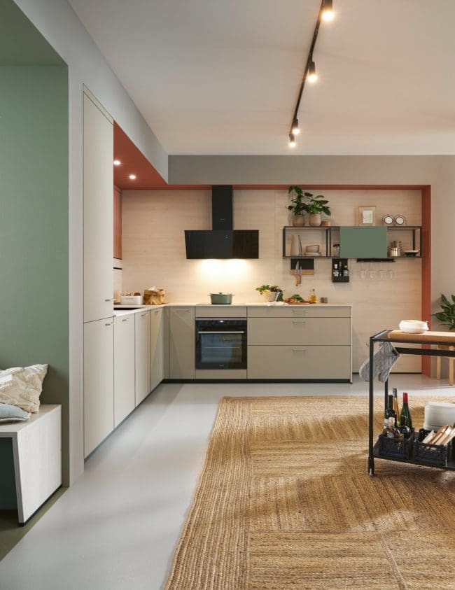 General view of a Schüller Matera kitchen, showcasing its full glory. This image captures the spacious layout, featuring the elegant matt black tambour unit, sleek anti-fingerprint cabinets in various colours, and the modern island at the heart. The blend of sustainable materials and contemporary design creates a welcoming, stylish space for cooking and gathering with family and friends.