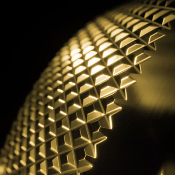 Image showcasing a section of a Bora extractor system, featuring a honeycomb filter bathed in warm, golden light, symbolising 'timeless design'. The intricate pattern of the filter combines functionality with a classic aesthetic, reflecting Bora's commitment to creating kitchen elements that are as enduring in design as they are in quality.